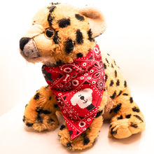 Load image into Gallery viewer, Classic red bandana print over-the-collar bandana.  Has classic bandana pattern with black and white dogs and white bones.  Displayed on a cute stuffed tiger toy.. 
