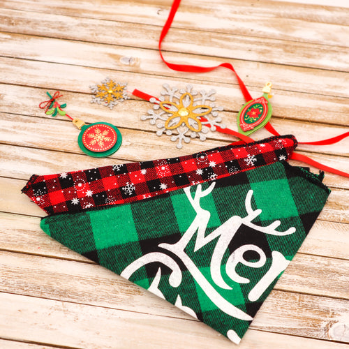 Picture of two Christmas pet bandanas.  Bandana 1 (front in picture) has a green and black buffalo plaid check pattern with Merry Christmas printed on it.  Bandana 2 has a red and black check pattern with white snowflake images superimposed.  Displayed on wooden board with red ribbon and Christmas ornament cut-outs. 