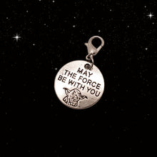 Load image into Gallery viewer, A picture of a silver round charm with the outline of Yoday and the words &quot;May the Force Be With You.&quot;  Charm has a lobster clasp and is displayed on a black night sky background. 
